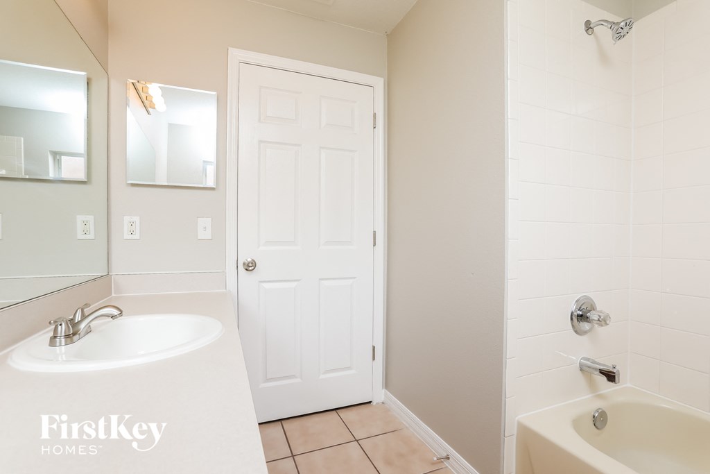 a bathroom with a sink and a shower and a door