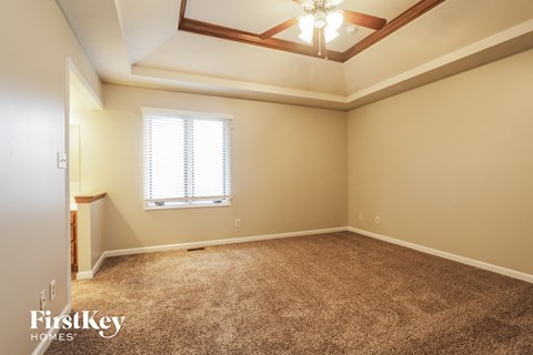 a empty living room with a ceiling fan and a window
