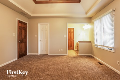 a room with a carpeted floor and a door and a window
