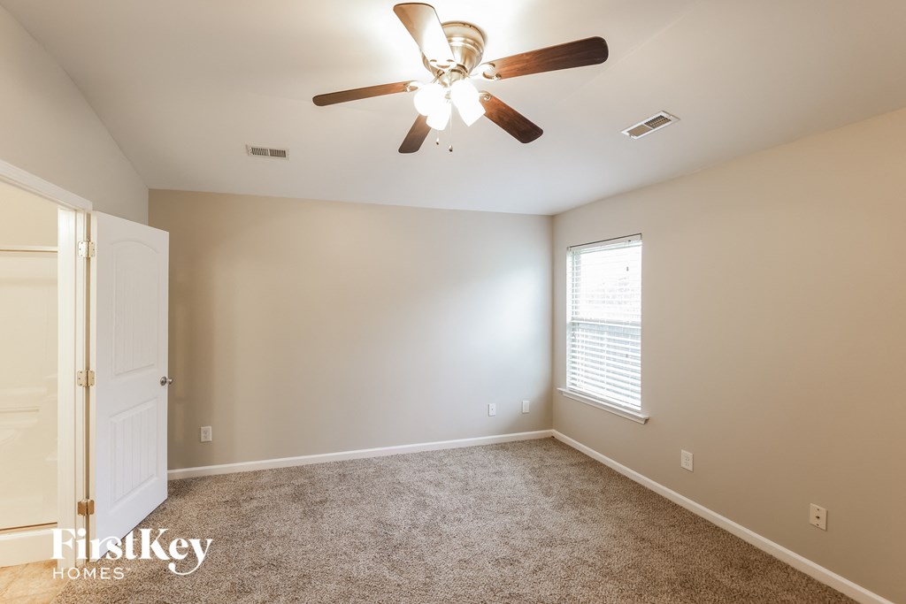 a bedroom with a ceiling fan and a white door