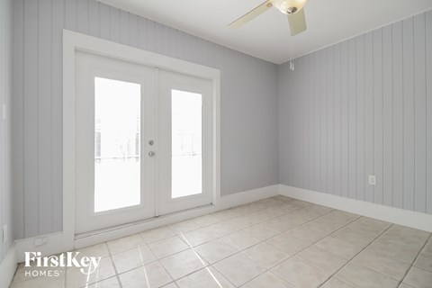 a living room with two doors and a tile floor