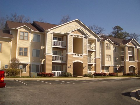 an apartment building with a parking lot in front of it