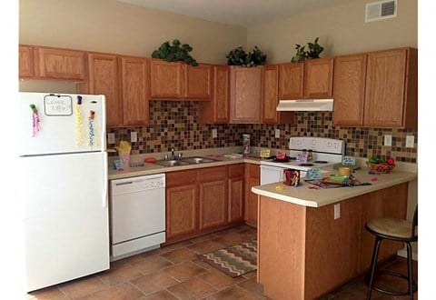 a kitchen with white appliances and wooden cabinets