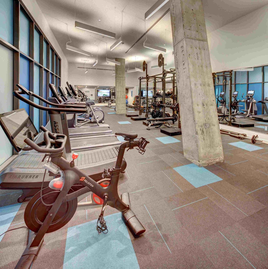 a gym with cardio equipment and weights in a building