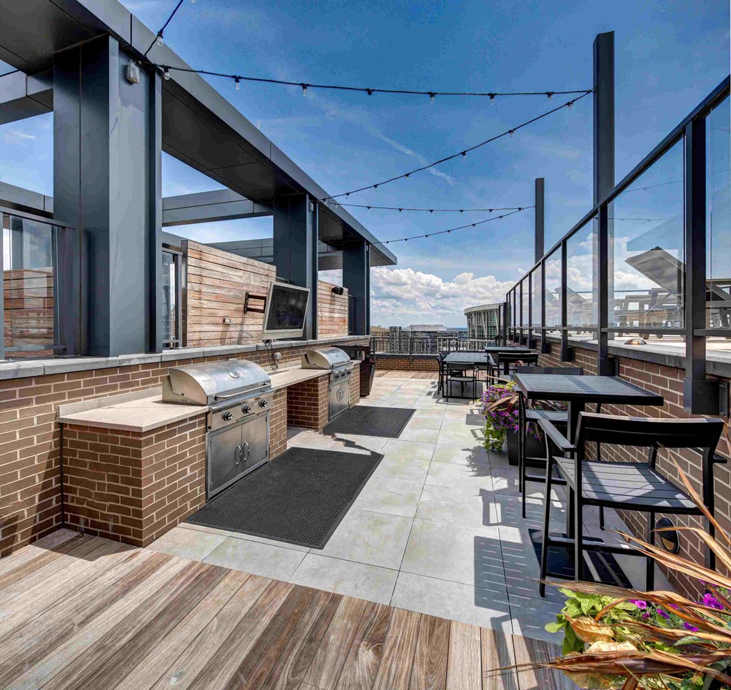 the outdoor patio of the building has a barbecue grill and tables