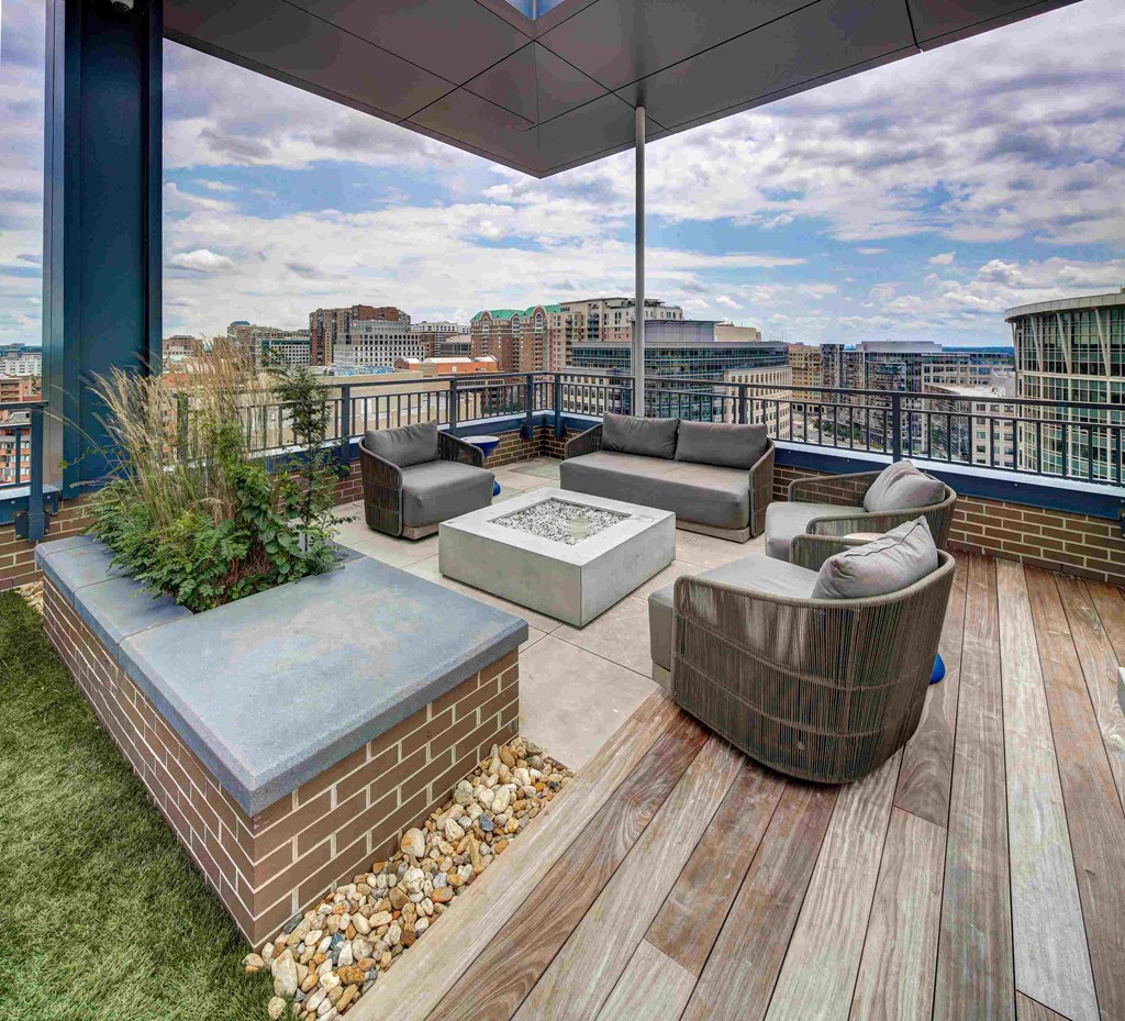a rooftop terrace with furniture and a view of the city