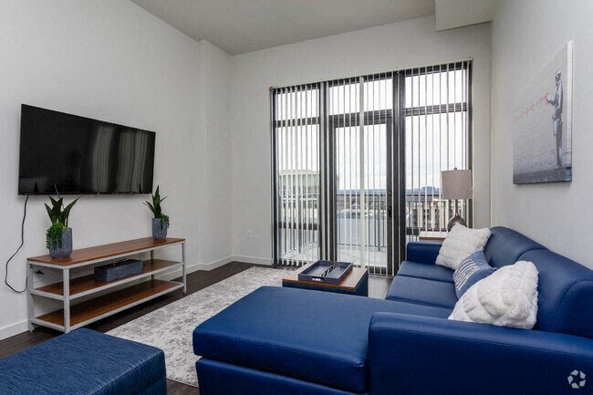 a living room with a blue couch and a television