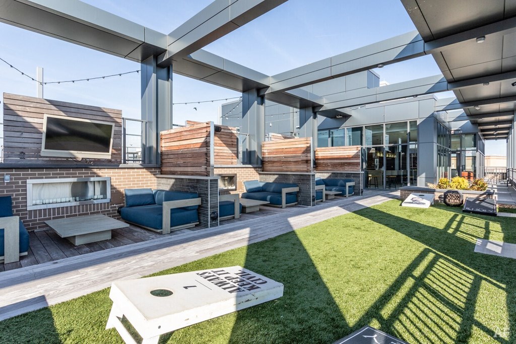 a rendering of a patio area with furniture and a television