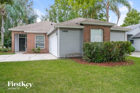 a small brick house with a yard and a garage door