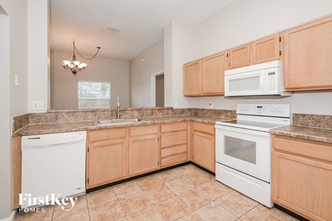 a large kitchen with white appliances and wooden cabinets