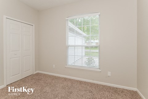 a bedroom with a window and a white door