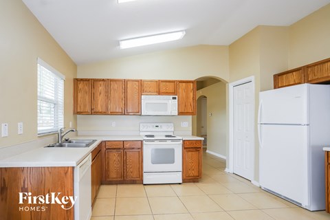 A kitchen with wooden cabinets and white appliances.