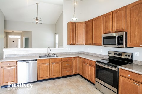 A kitchen with wooden cabinets and a stainless steel dishwasher.