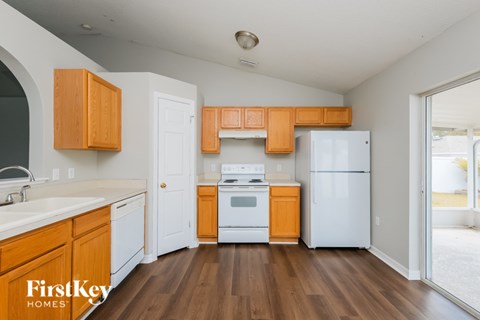 A kitchen with wooden cabinets and a white fridge.