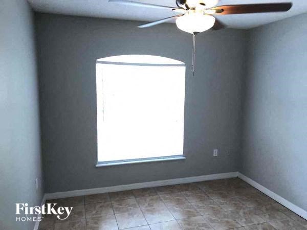 A room with a fan and a window.
