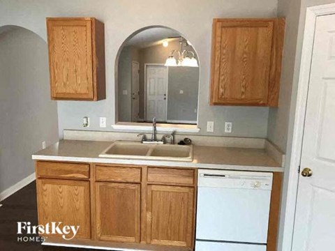 A kitchen with wooden cabinets and a white dishwasher.