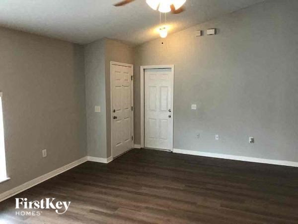 A room with a wooden floor and a ceiling fan.