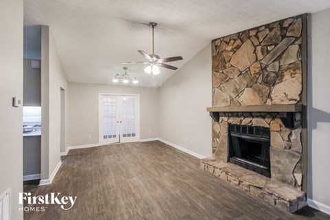 a living room with a fireplace and a ceiling fan
