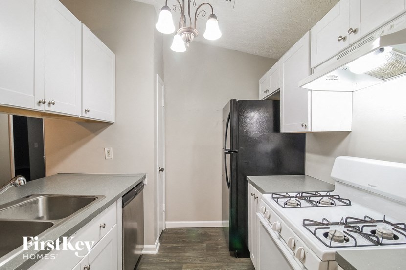 a kitchen with white cabinets and a stove and a refrigerator