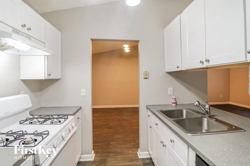a kitchen with white cabinets and a stove and a sink