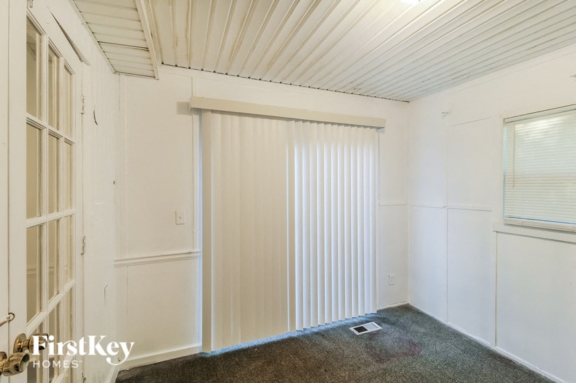 a small room with white walls and a sliding glass door