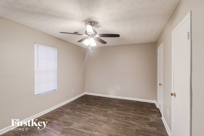 the living room of an empty home with a ceiling fan