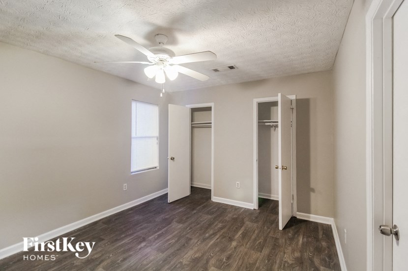 a bedroom with a ceiling fan and a closet