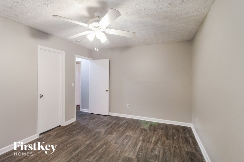 a bedroom with a ceiling fan and a door to a closet
