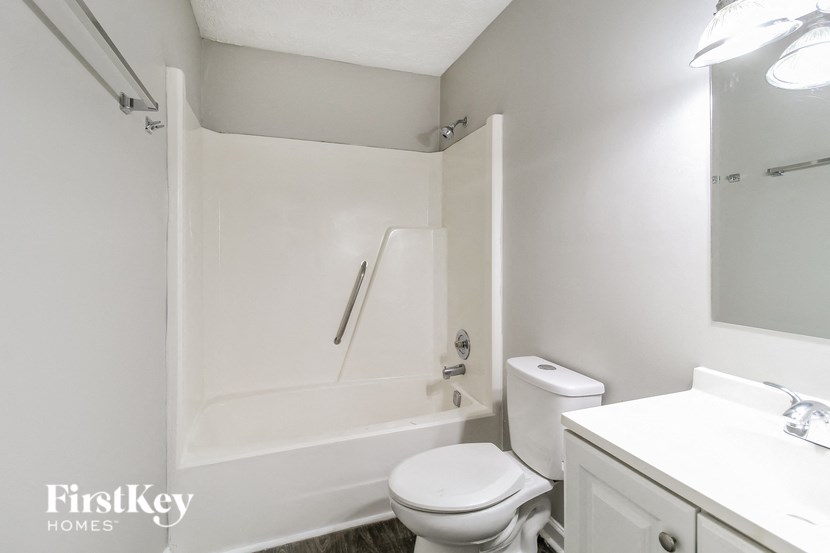 a white bathroom with a toilet and a tub and a sink