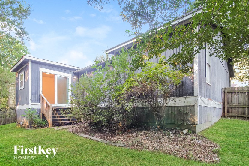 a small house with a yard and a tree
