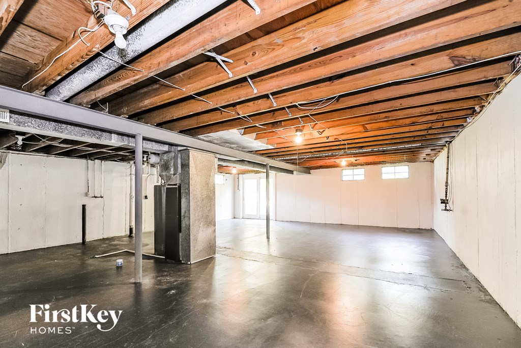 A spacious room with a wooden ceiling and a FirstKey Homes logo.