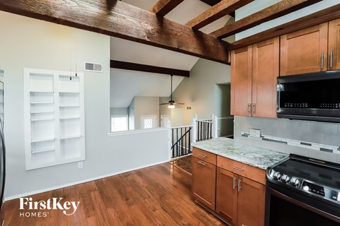 A kitchen with wooden cabinets and a black stove top oven.