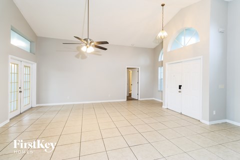 A spacious room with a ceiling fan and tiled flooring.