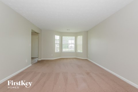 a spacious living room with wood floors and white walls