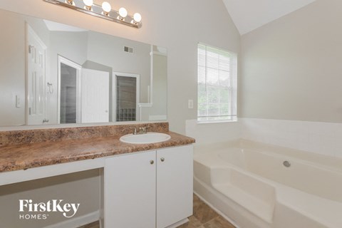 a bathroom with a tub and a sink and a mirror