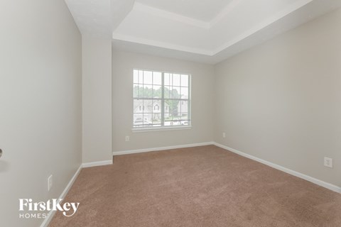 a spacious living room with carpet and a window