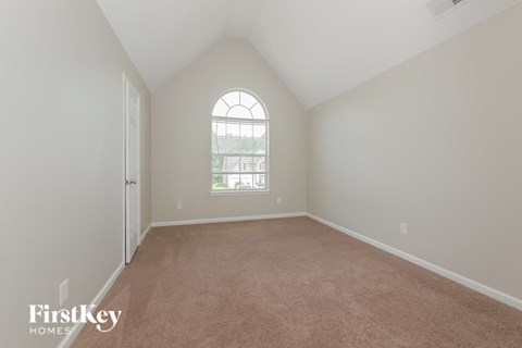 a bedroom with a carpeted floor and a large window