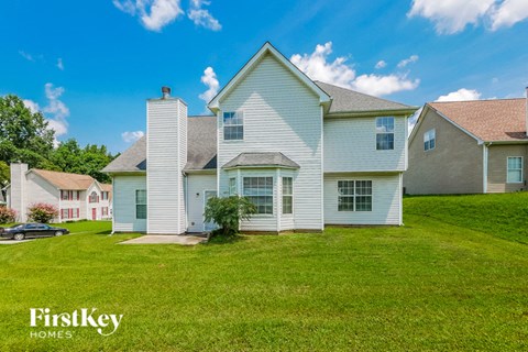 a white house with white siding and a green lawn