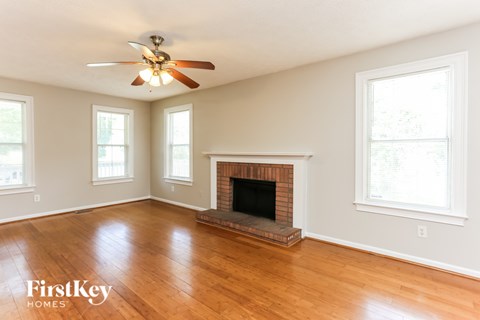 A room with a fireplace and a ceiling fan.