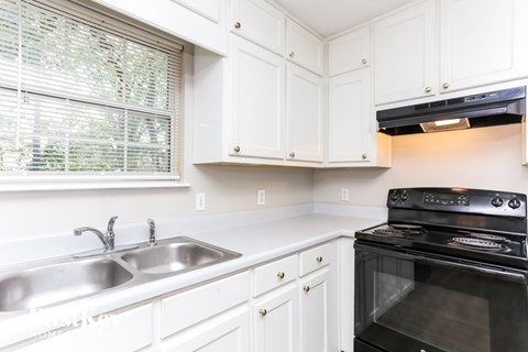 A black oven is built into a white kitchen counter.