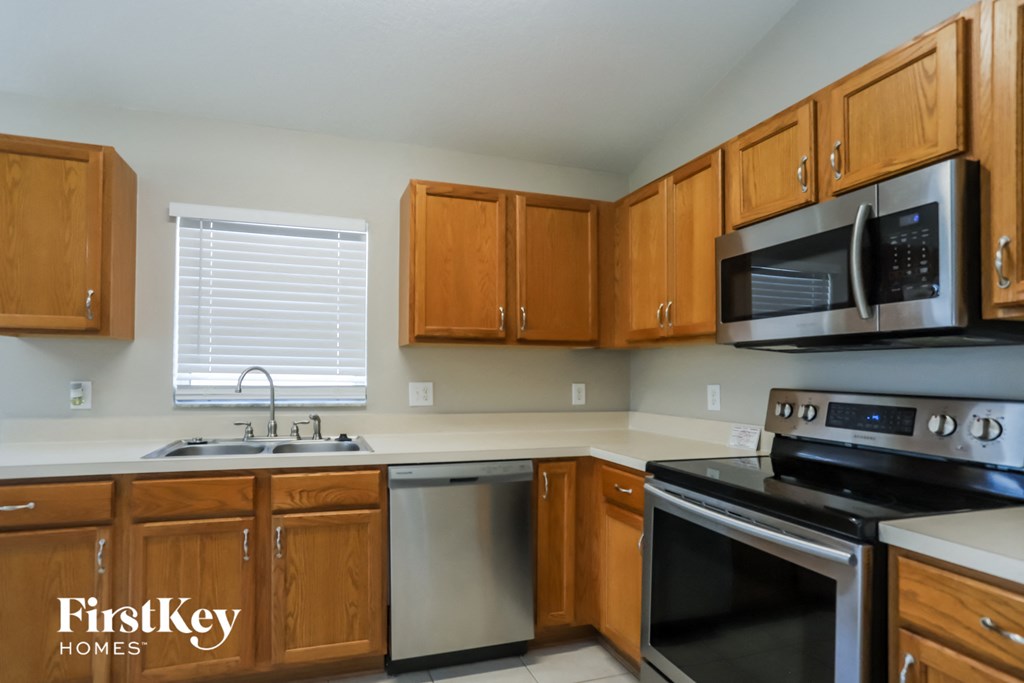 a kitchen with wooden cabinets and stainless steel appliances