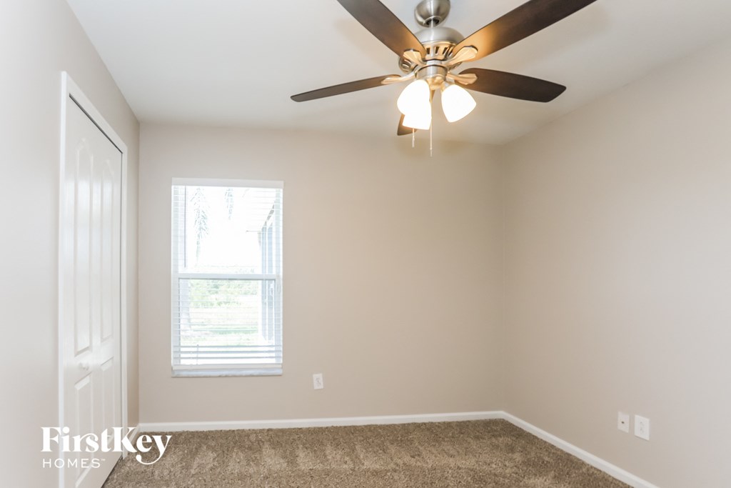 a bedroom with a ceiling fan and a window