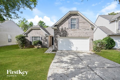 a white and gray brick house with a white garage door