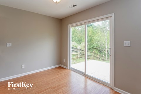 an empty living room with a large window and wood flooring