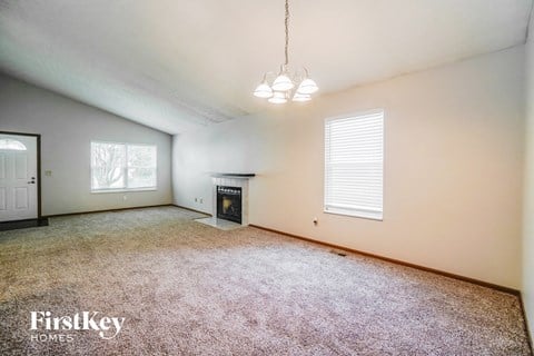 a spacious living room with carpet and a fireplace