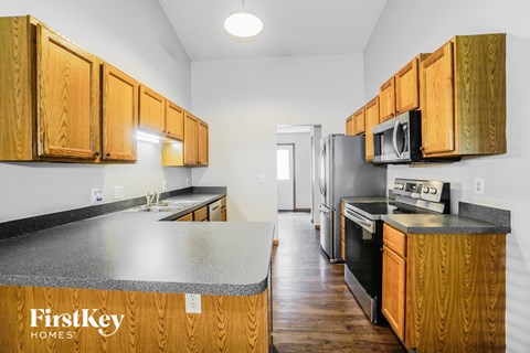 a kitchen with wooden cabinets and black appliances