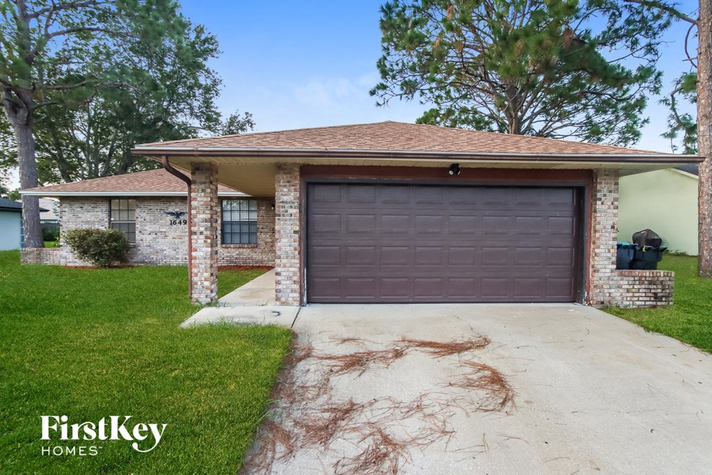 a driveway with a garage door in front of a house