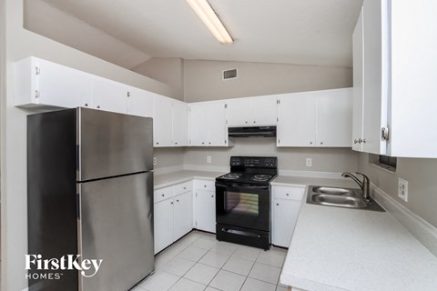 a kitchen with white cabinets and a black stove and refrigerator