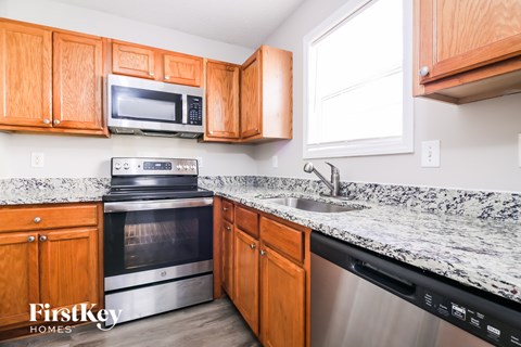 A kitchen with wooden cabinets and granite countertops.