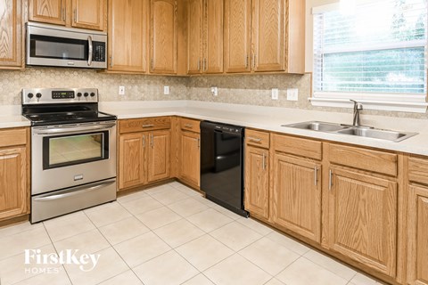 A kitchen with wooden cabinets and a stainless steel oven.